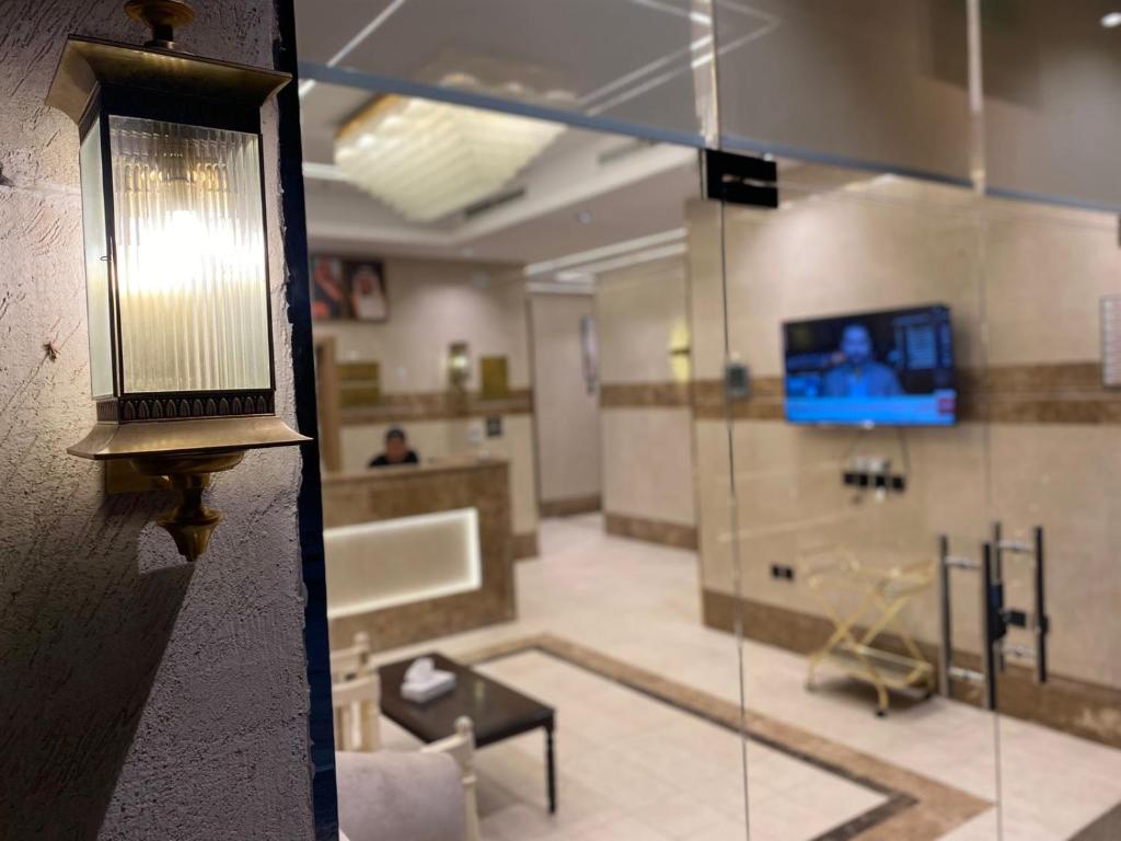 a living room with a light on a wall at Orchid Hotel Madinah in Al Madinah