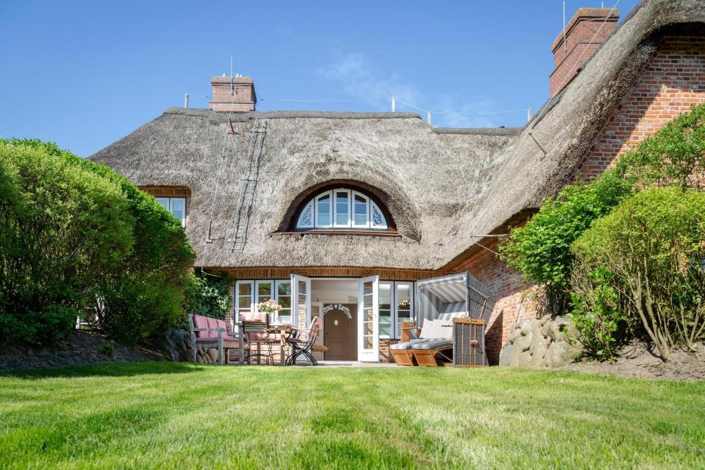 a house with a thatched roof with a yard at NEU Dorfhues Anja friesisch modern urlauben in Kampen Sylt in Kampen