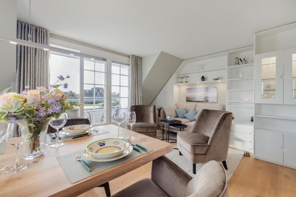 a dining room with a table and chairs and a living room at Ferienwohnung Waterkant in Munkmarsch