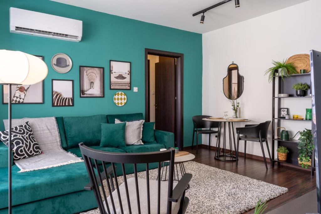 un salon avec un canapé vert et une table dans l'établissement Harbor 101 Stylish 1BR Apartment in Larnaca, à Larnaka