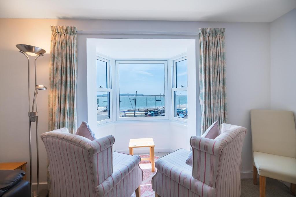 a living room with two chairs and a window at Fabulous Sea View Apartment in Aberdyfi