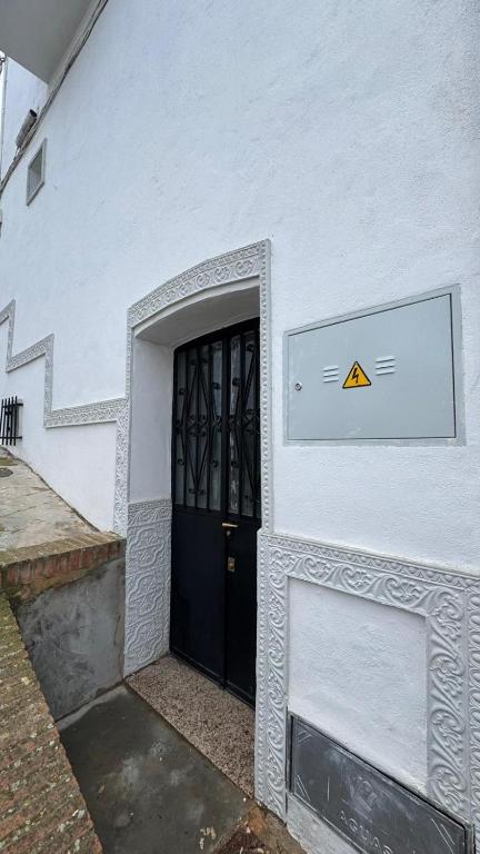 ein Gebäude mit einer Tür, an der ein Schild hängt in der Unterkunft Encantadora casa en Aroche in Aroche