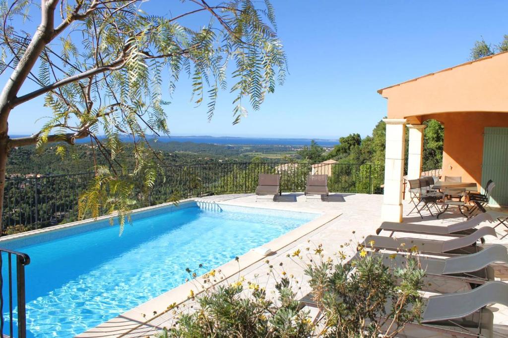 - une piscine avec des escaliers et des chaises à côté d'une maison dans l'établissement Villa Camelia pour 8 personnes avec piscine et vue mer au domaine de Valcros à La Londe les Maures, à La Londe-les-Maures