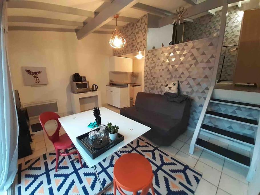 - un salon avec une table blanche et des chaises rouges dans l'établissement Jolie chartreuse avec jardin privé, à Toulouse