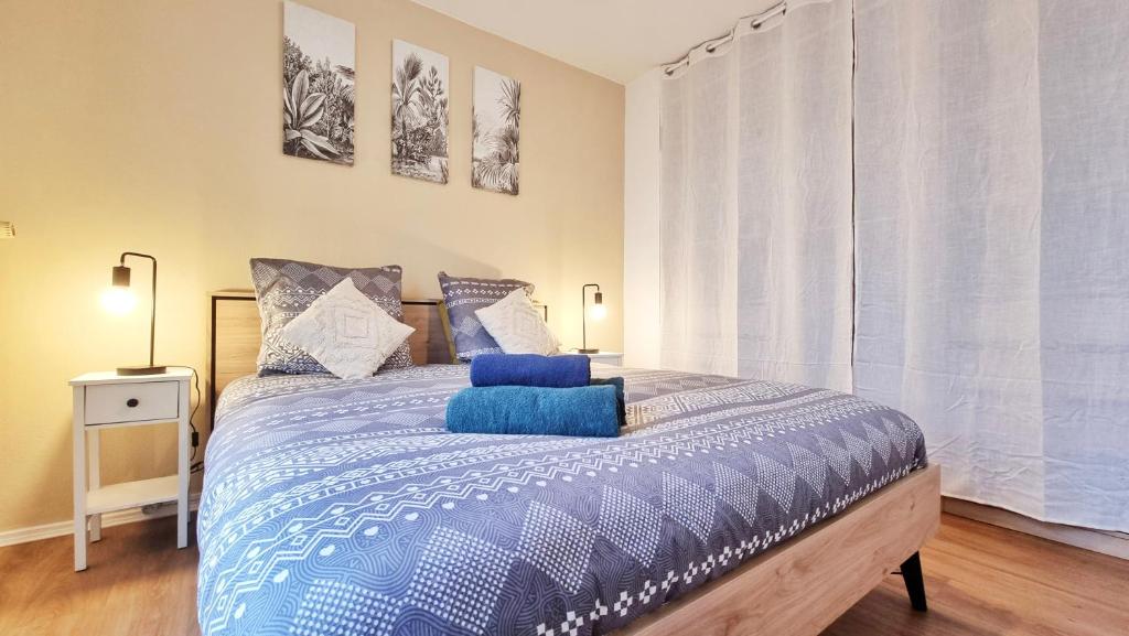 une chambre avec un lit avec une couette bleue dans l'établissement Le Petit Léon - Colmar - Fibre - RBNB, à Colmar
