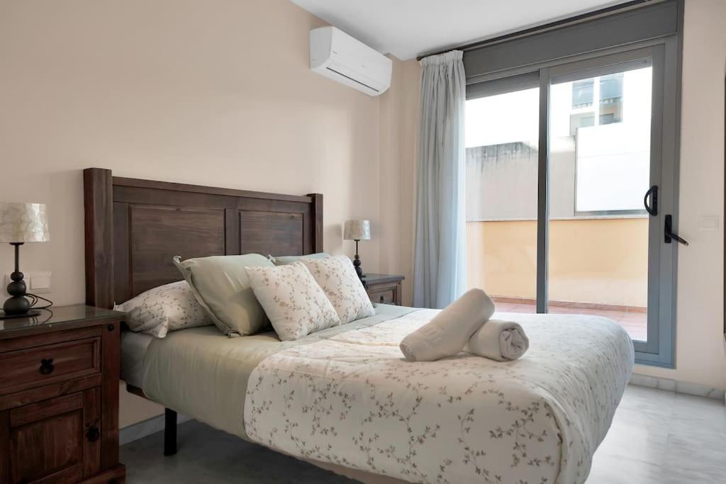 ein Schlafzimmer mit einem großen Bett und einem großen Fenster in der Unterkunft Apartamento con terraza y piscina en Puerto Marina - MISTRAL in Benalmádena
