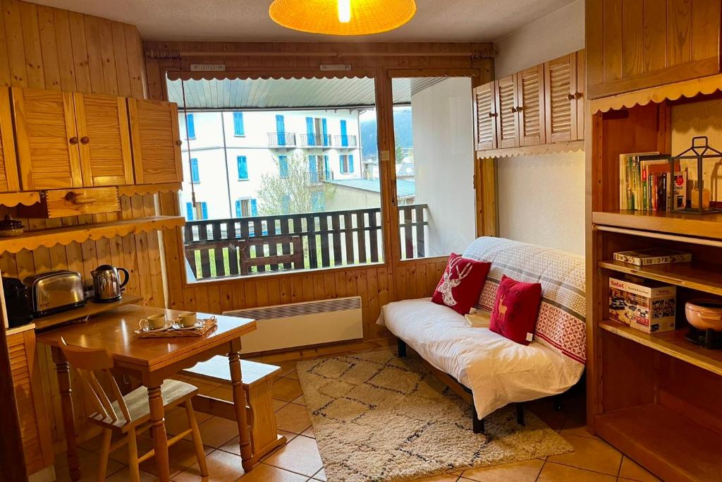 une cuisine avec un canapé, une table et une fenêtre dans l'établissement City center studio near the slopes, à Chamonix-Mont-Blanc