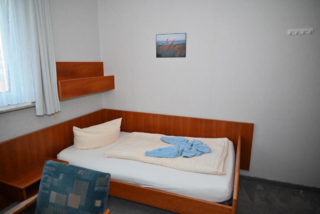 Un pequeño dormitorio con una cama y una silla. en Einzelzimmer-07-OG-Meerblick, en Borkum