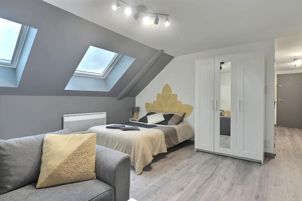 - une chambre avec un lit, un canapé et des fenêtres dans l'établissement Élégance Urbaine, à Belfort