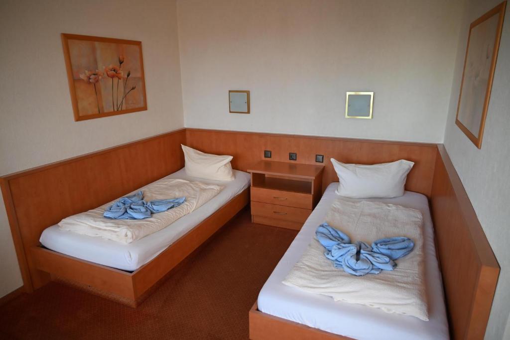 two beds in a small room with blue sheets at Zweibettzimmer-08-OG in Borkum
