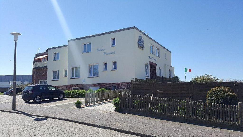 a white building with a fence in front of it at Budget-Einzelzimmer-06-EG in Borkum