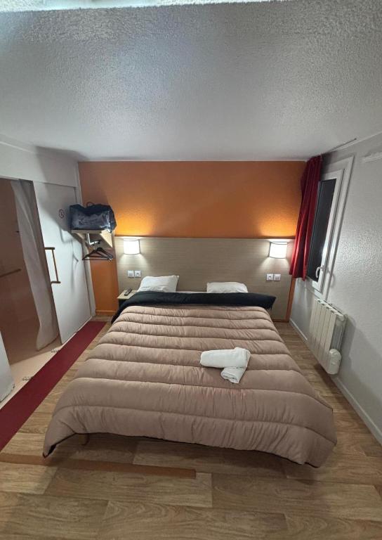 une chambre avec un grand lit avec deux serviettes dessus dans l'établissement Classic Hôtel - Fontenay-Trésigny, à Fontenay-Trésigny