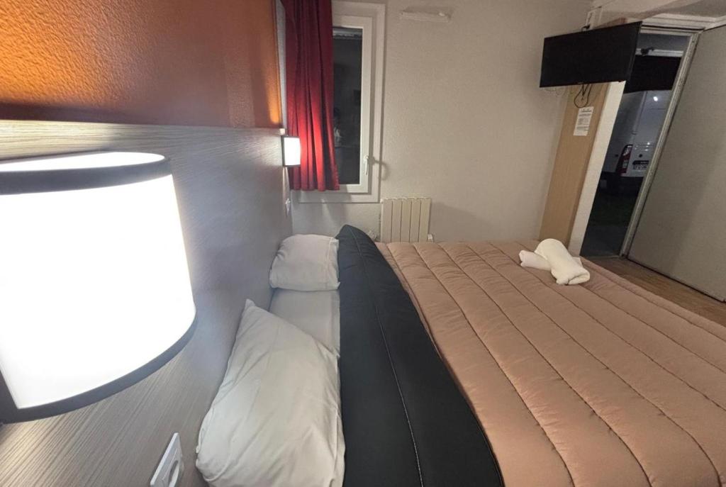 un dormitorio con una cama en una habitación en Classic Hôtel - Fontenay-Trésigny, en Fontenay-Trésigny