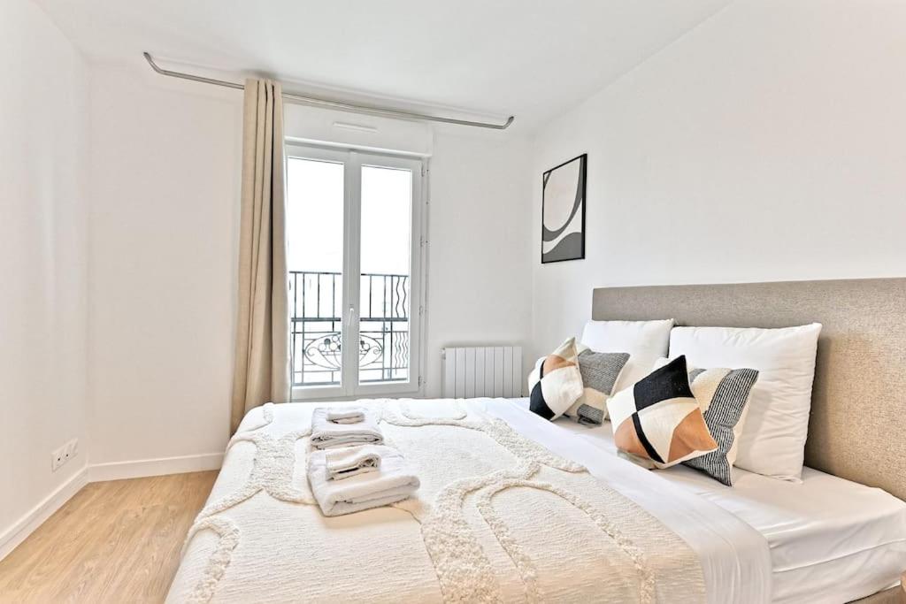 une chambre blanche avec un grand lit avec une fenêtre dans l'établissement Studio charmant tout équipé Paris Montreuil - IV, à Montreuil