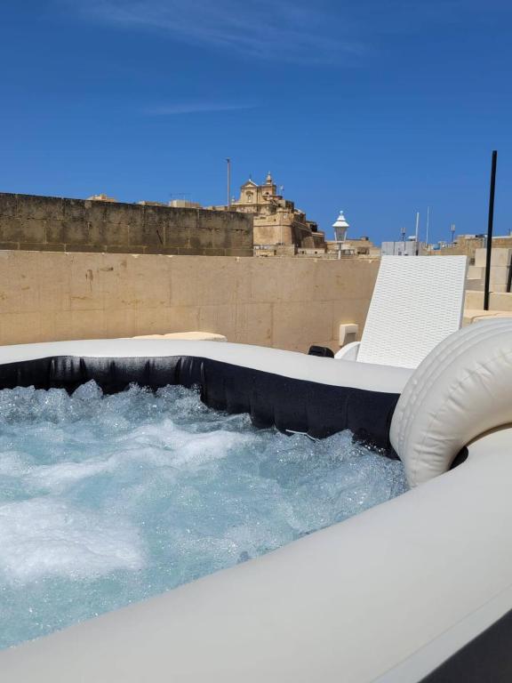 a hot tub on a roof with a chair at Citadella X Casa Jorge in Victoria