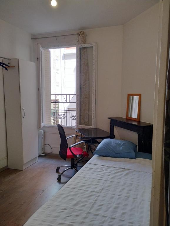 une chambre avec un lit, un bureau et une chaise dans l'établissement Charmant studio en centre ville, à Saint-Ouen