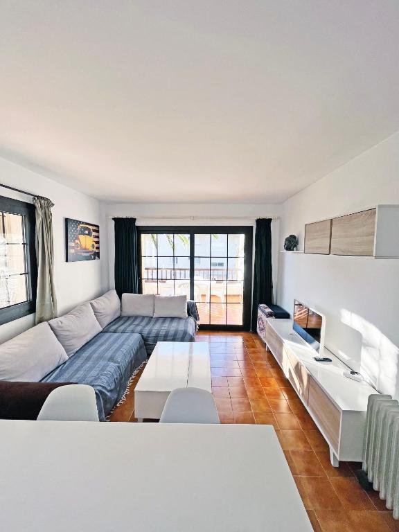 una sala de estar con un sofá y una mesa en Apartamento en la Escala con piscina y parking, en L'Escala