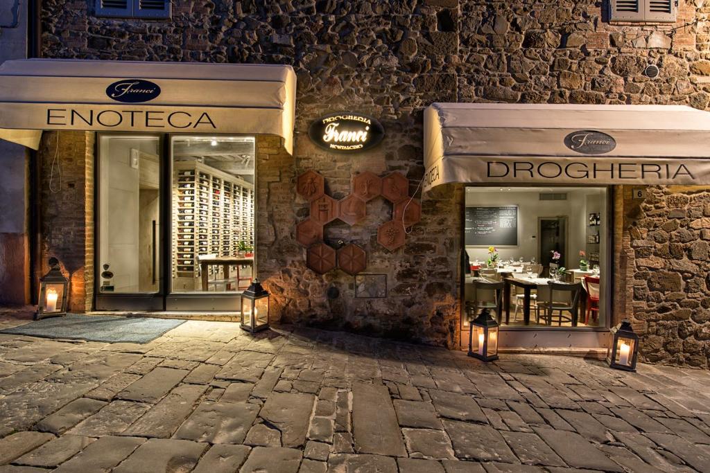 a restaurant with a sign on the side of a building at Drogheria e Locanda Franci in Montalcino
