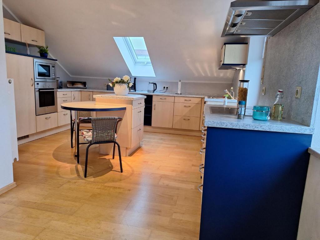 a large kitchen with a table and a blue wall at Ferienwohnung Obertshauser in Nittenau