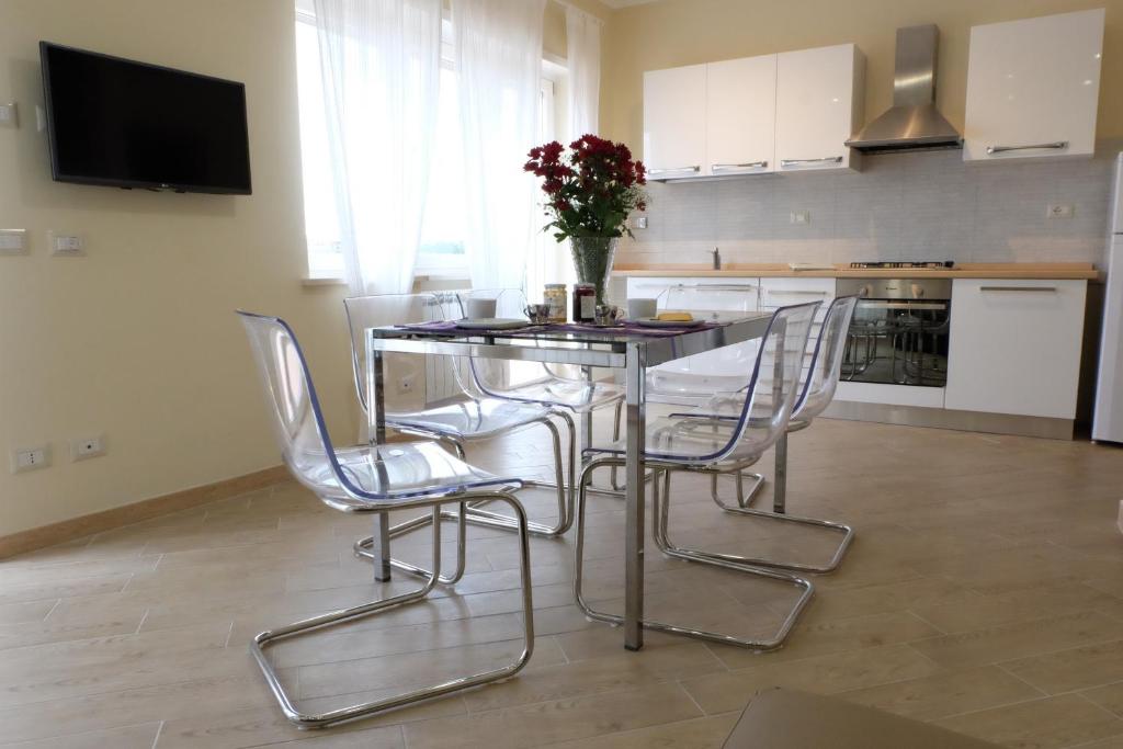 a kitchen with a table with chairs and a vase of flowers at Terrazza sul Parco in Rome