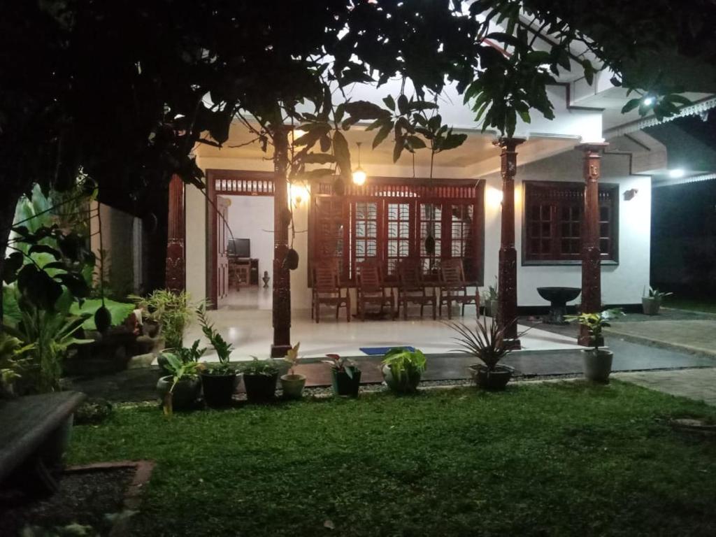 a house with a courtyard at night with plants at Shine Day villa in Weligama
