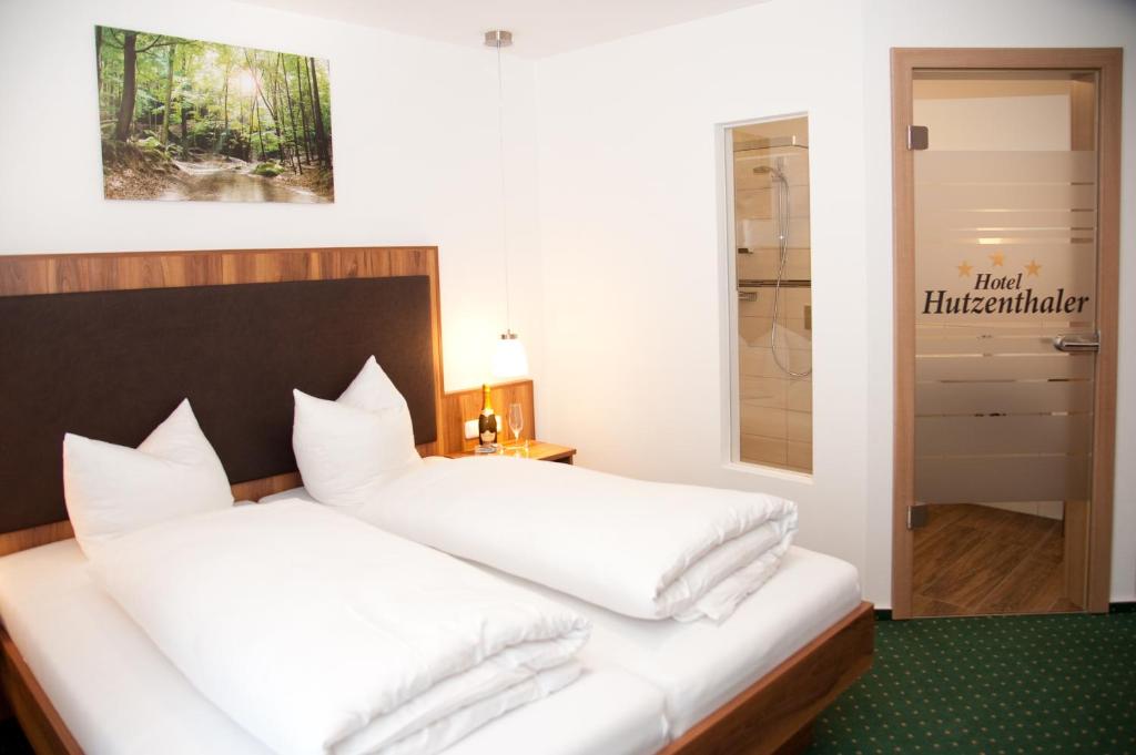 ein Schlafzimmer mit zwei weißen Kissen auf einem Bett in der Unterkunft Hotel Hutzenthaler in Bruckberg