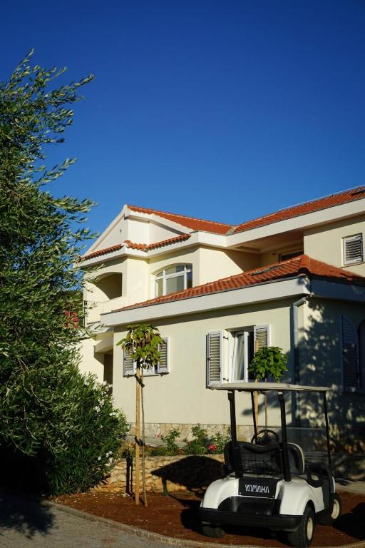 wózek golfowy zaparkowany przed domem w obiekcie Apartment Tasha w mieście Ist