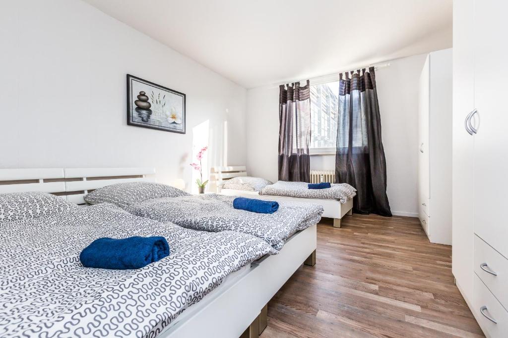 ein Schlafzimmer mit 2 Betten und blauen Kissen darauf in der Unterkunft Work & stay Monheim in Monheim
