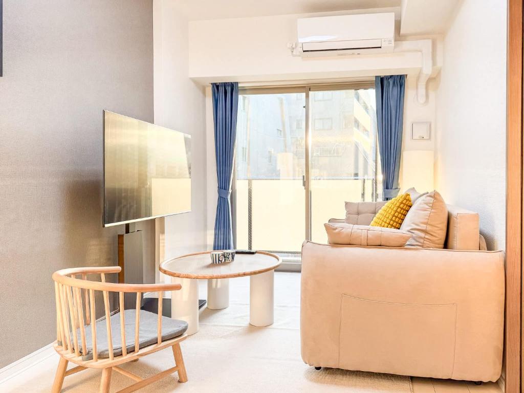 a living room with a couch and a chair at Triphome Tokyo Sugamo 2024 New 3 mins 2 stations in Tokyo