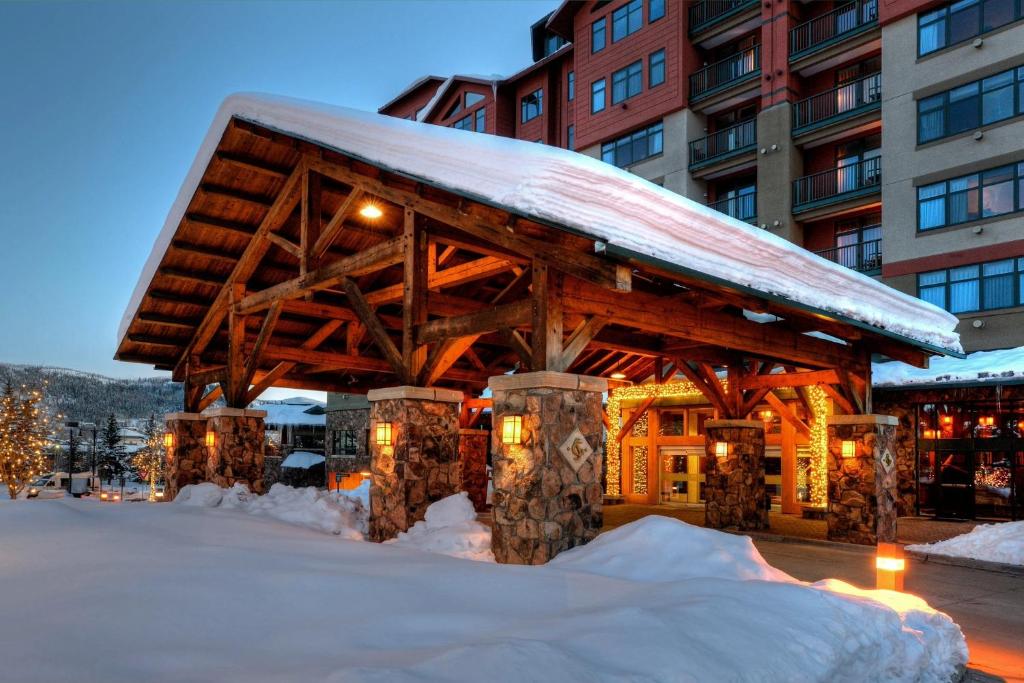 a building covered in snow in front of a building at The Steamboat Grand in Steamboat Springs