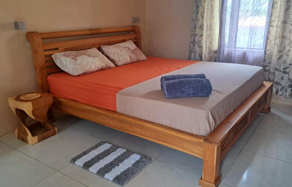 a bed in a bedroom with a wooden bed frame at Gris Gris Studio 1 in Souillac