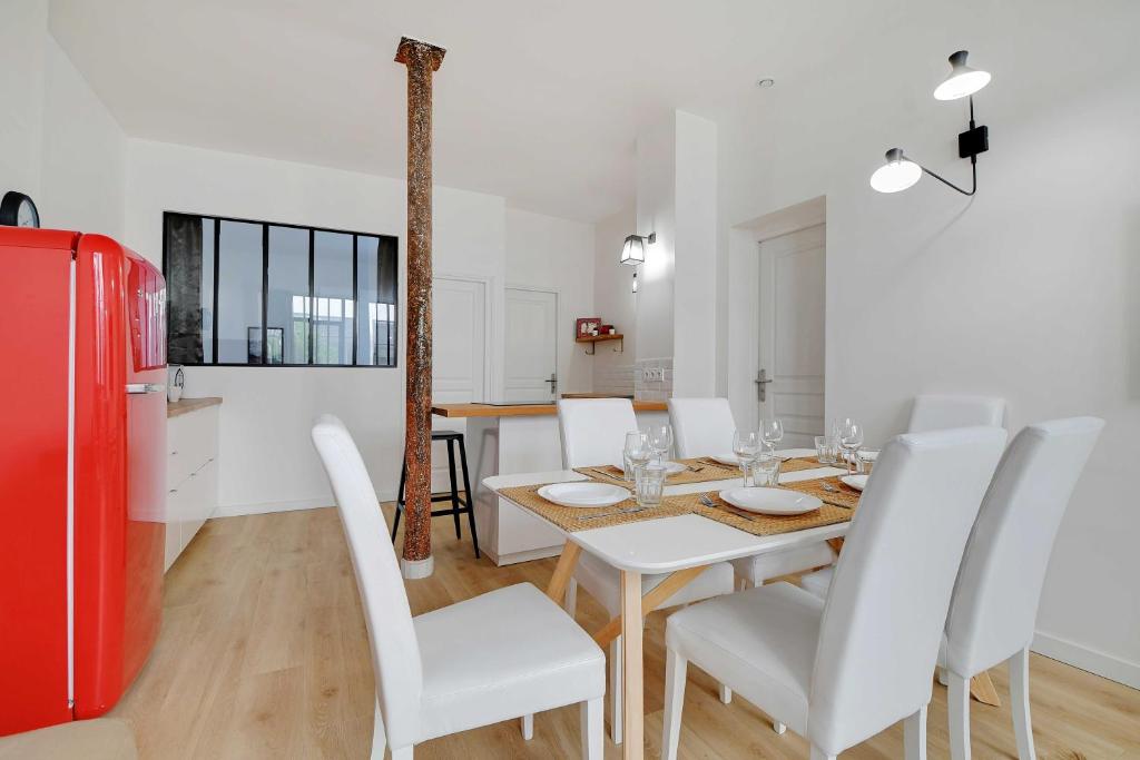 - une salle à manger avec une table et un réfrigérateur rouge dans l'établissement Loft d'Exception pour 6 Personnes - Voltaire 11e, à Paris