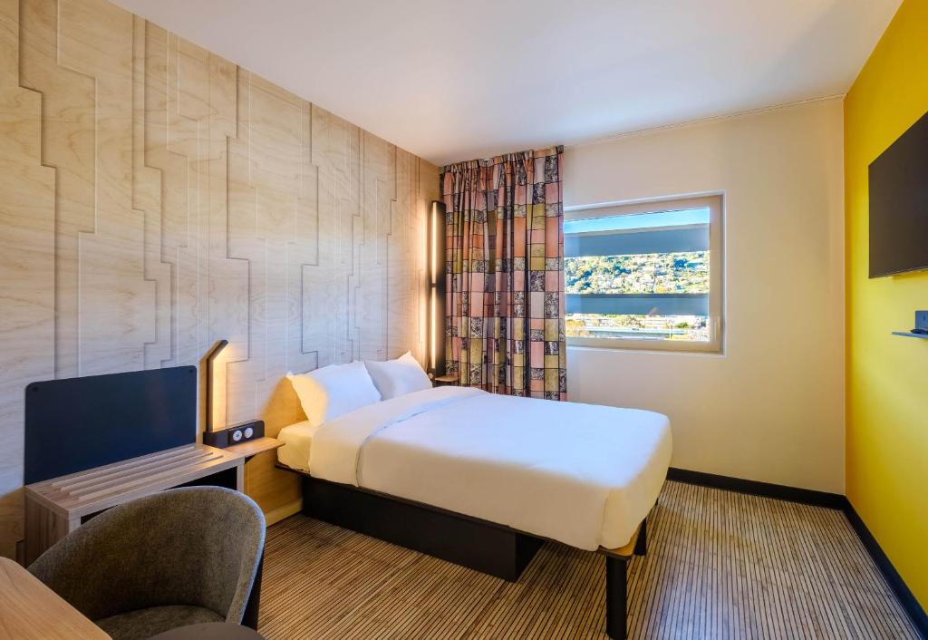 ニースにあるB&B HOTEL Nice Stade Rivieraのベッドと窓のあるホテルの部屋