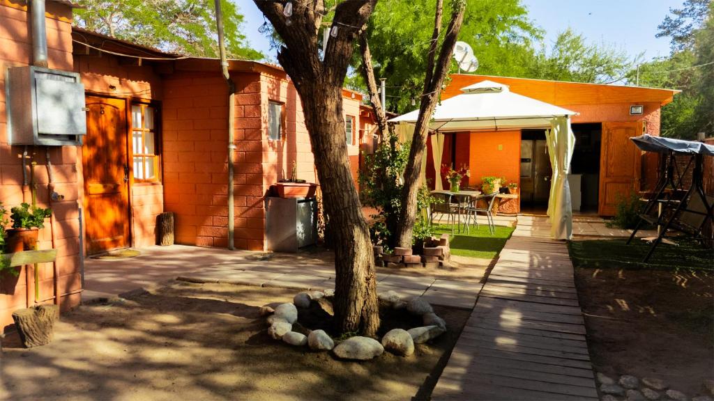 a tree in a yard next to a house at Hostal Perita in San Pedro de Atacama