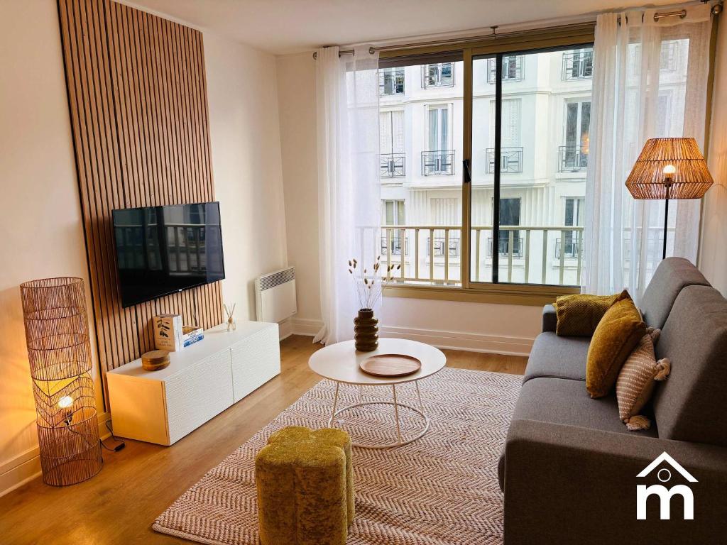 un salon avec un canapé et une télévision dans l'établissement St Honore Champs Elysees by Melvane, à Paris