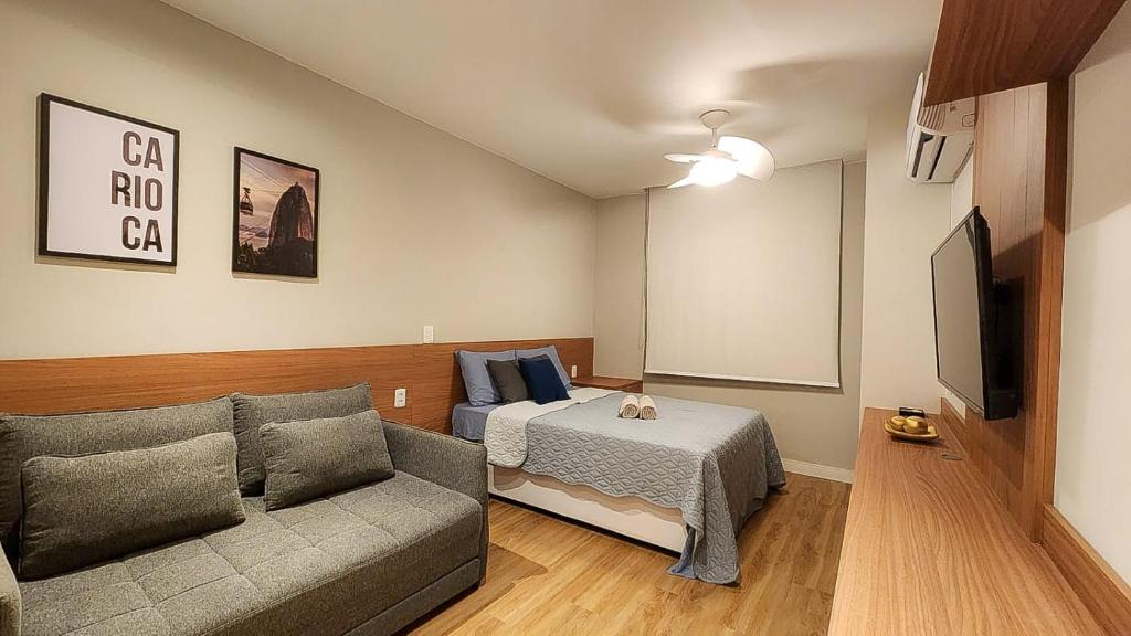 a living room with a couch and a bed at Em frente à praia - conforto, localização e vista in Rio de Janeiro