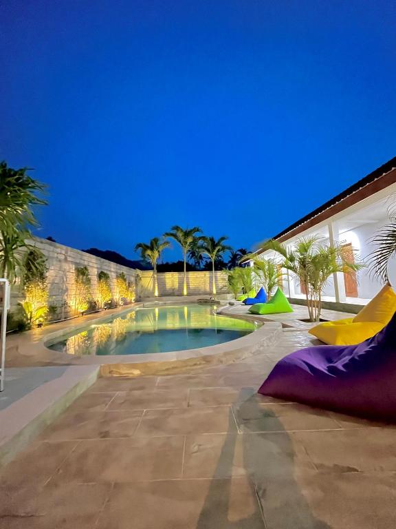 una piscina nel mezzo di un cortile di notte di Jancoox Hostel a Kuta Lombok