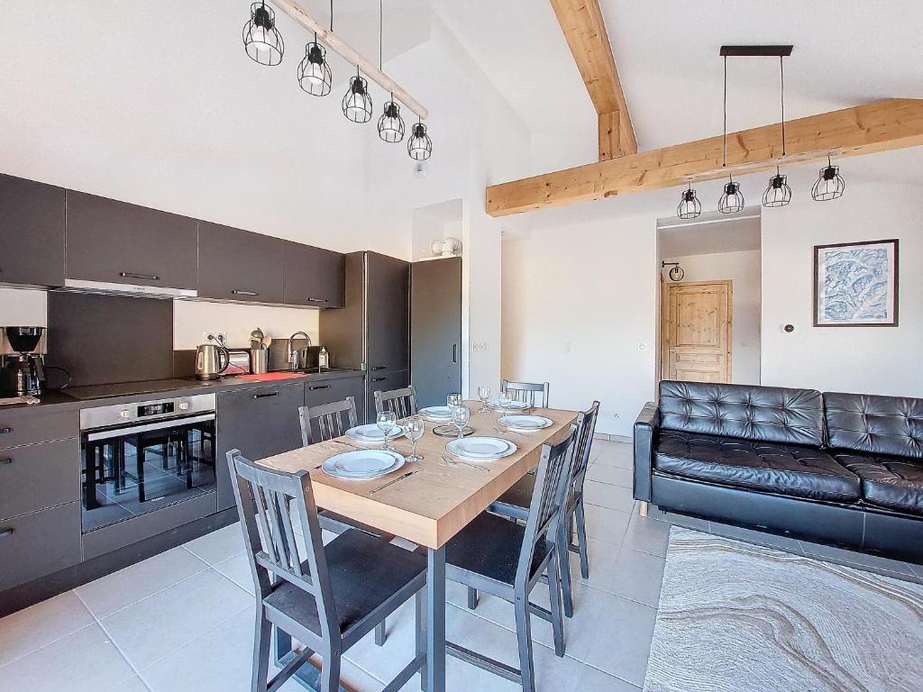 une cuisine et une salle à manger avec une table et des chaises dans l'établissement Snow Roc B302, à Saint-Jean-dʼAulps