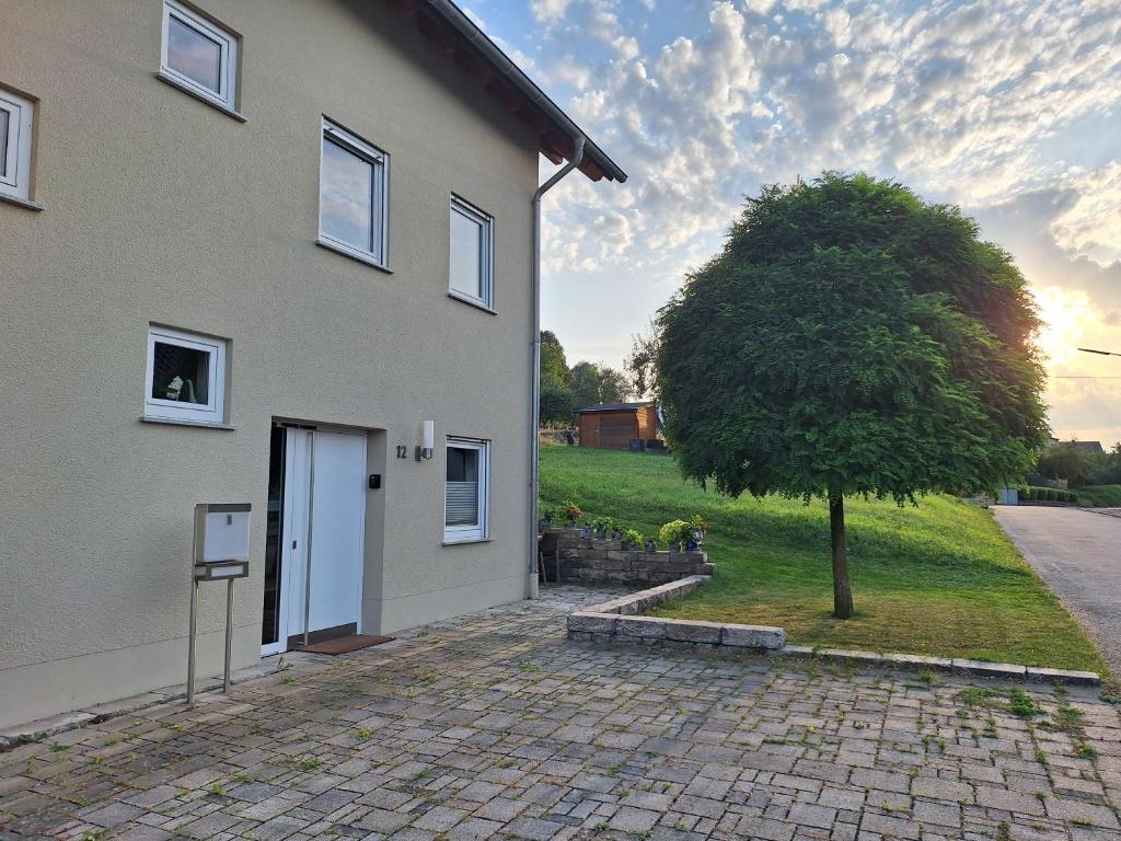 ein Haus mit einem Baum davor in der Unterkunft Ferienwohnung an der Obermosel in Oberbillig