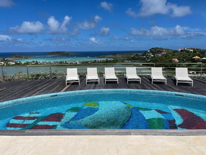 une piscine avec des chaises et une vue sur l'océan dans l'établissement Villa BOT- EVERSAIL avec vue panoramique sur l'océan, à Saint Barthelemy