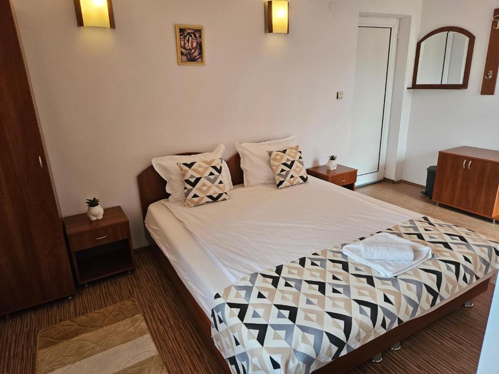 a bedroom with a bed with pillows on it at Cтаи за гости Бърдареви in Bansko