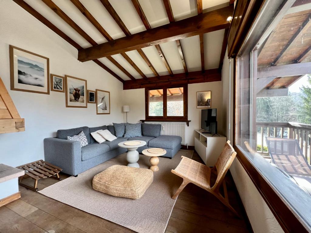 un salon avec un canapé bleu et une table dans l'établissement Arbois, à Megève