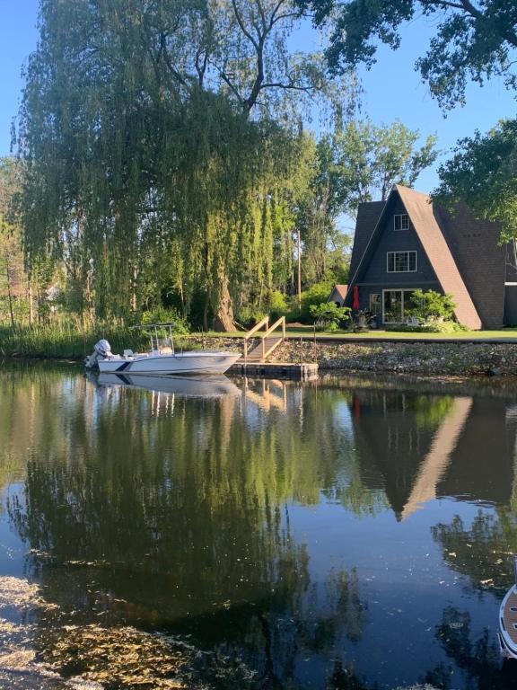 a house and a lake with a boat in front at Lazy Daze Lagoon by Simple Life Rentals in Sturgeon Bay