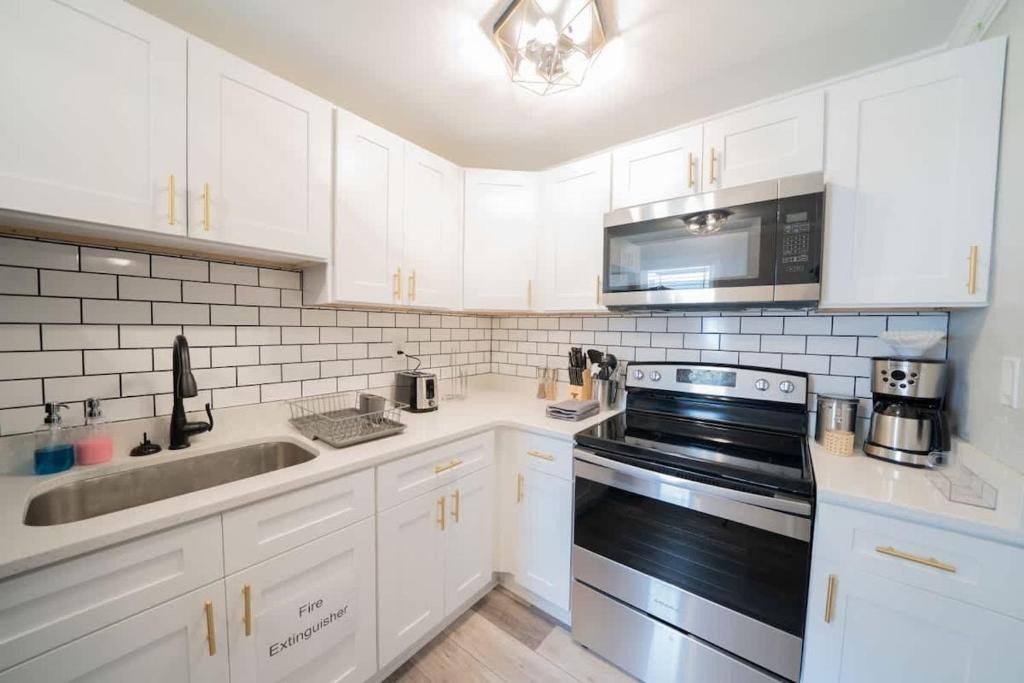 a white kitchen with a sink and a stove at OV Mosaic - Topaz Suite in North Camellia Acres