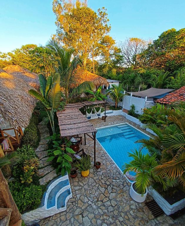 a backyard with a swimming pool and a wooden deck at Hotel Cabañas Puesta del Sol in Las Peñitas