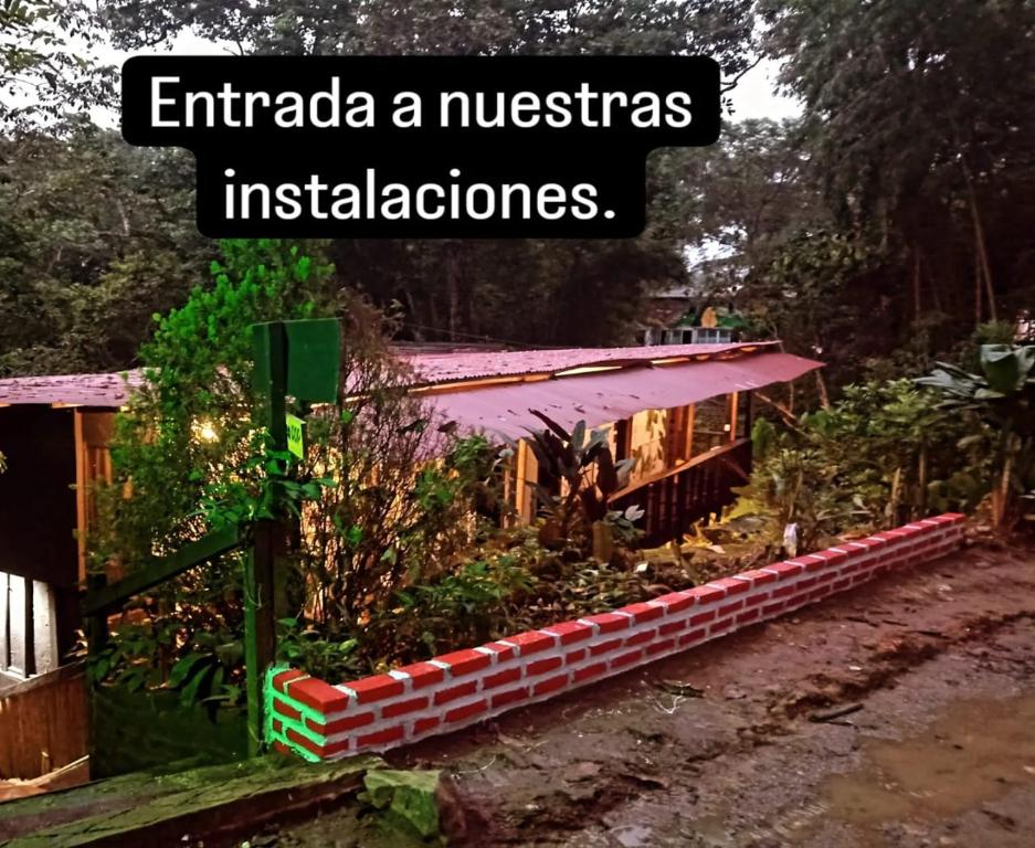 a garden with a sign that reads entaria auchenias instalations at Hostal Las Mariposas Minca in Minca