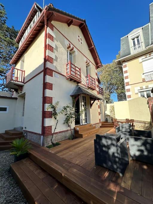 a house with a wooden deck in front of it at Charmante maison Cabourgeaise in Cabourg
