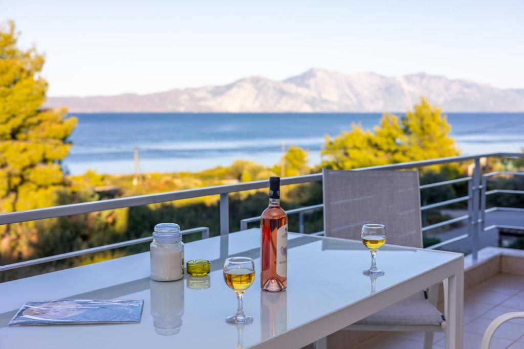 a table with wine bottles and glasses on a balcony at Ellie's house Theologos in Theológos