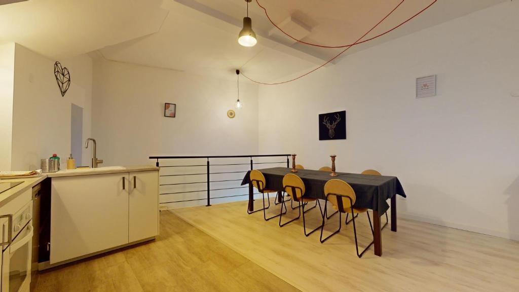 une cuisine avec une table et des chaises dans une pièce dans l'établissement Le Nid Caché Mulhouse, à Mulhouse