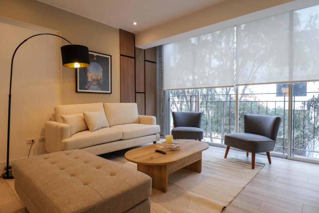 リマにあるCharming 2BR with Balcony in Mirafloresのソファとテーブルのあるリビングルーム